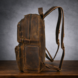 Side profile of leather travel rucksack showing padded straps and side pockets