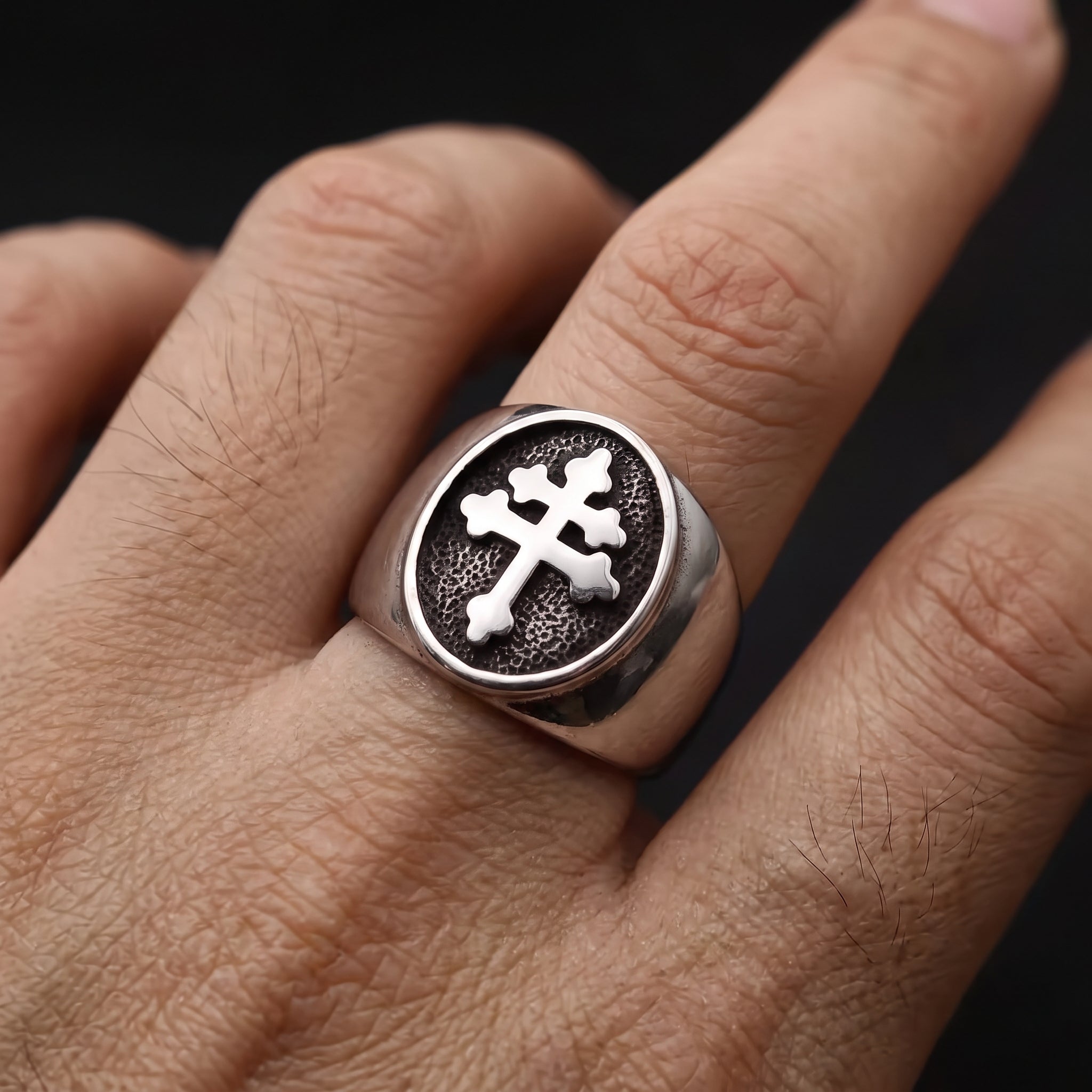 Man wearing the Cross of Lorraine stainless steel signet ring on his finger, showing the bold Christian cross design