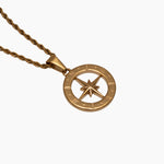 Gold north star compass pendant necklace on a white background