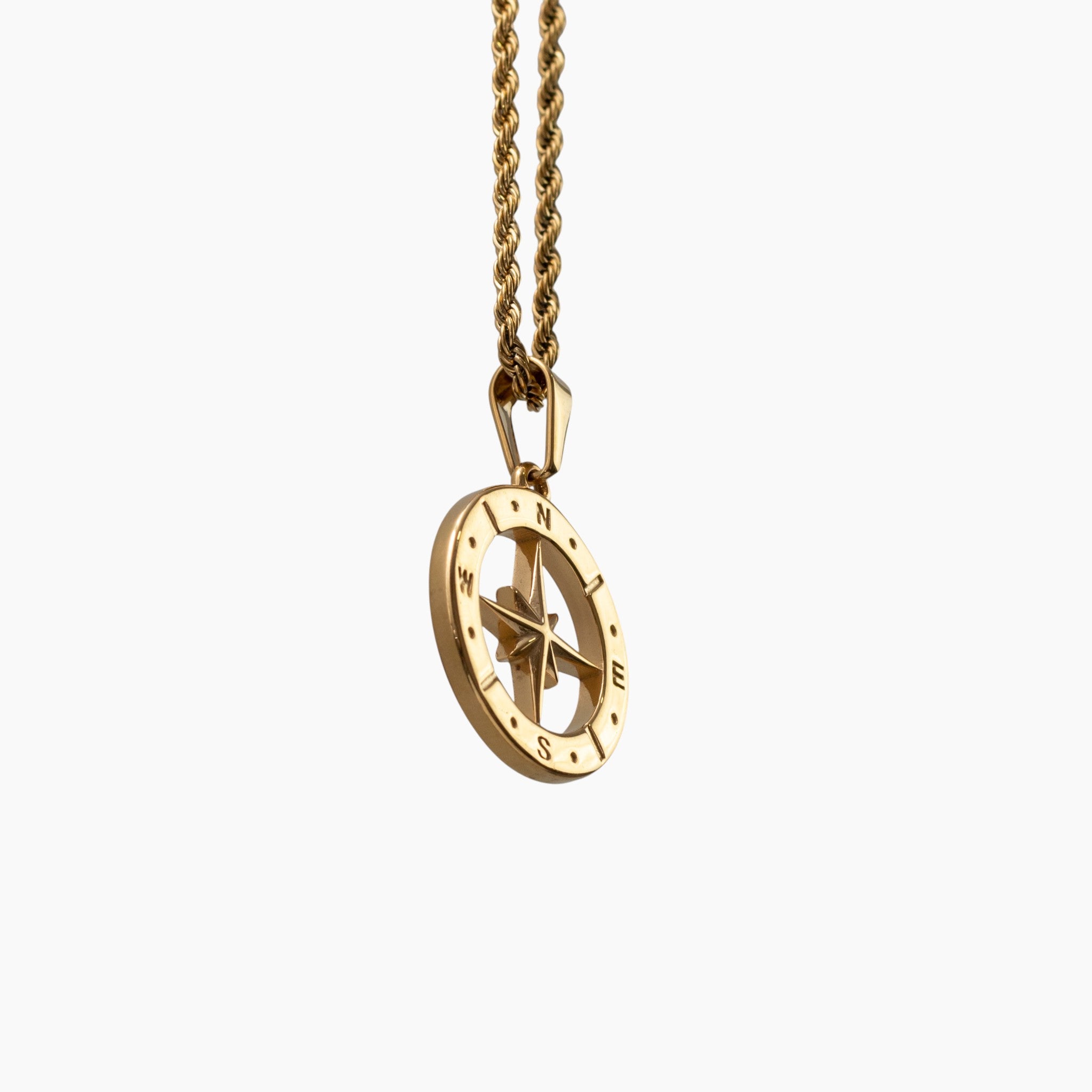Gold north star compass necklace on a white background