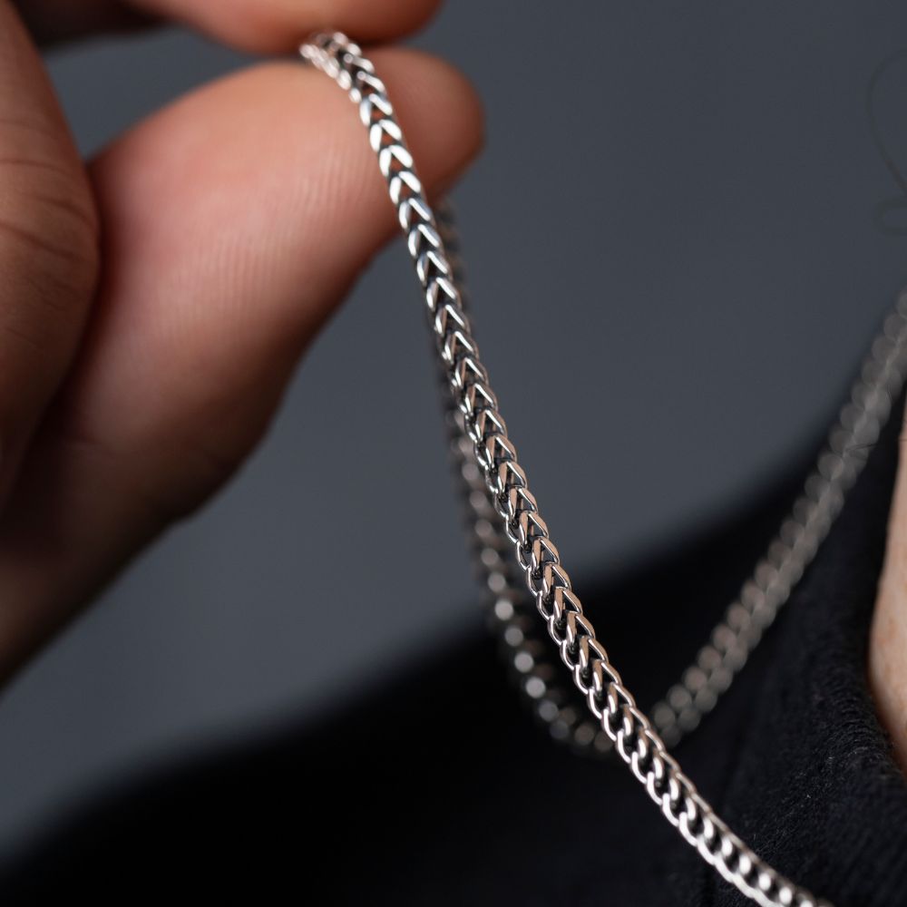 Hand holding 925 silver Franco chain, close-up of woven link texture