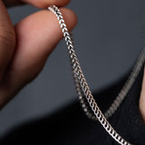 Hand holding 925 silver Franco chain, close-up of woven link texture