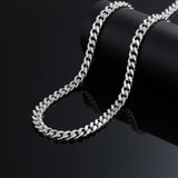 925 silver Cuban link chain draped over display stand, close-up on black background