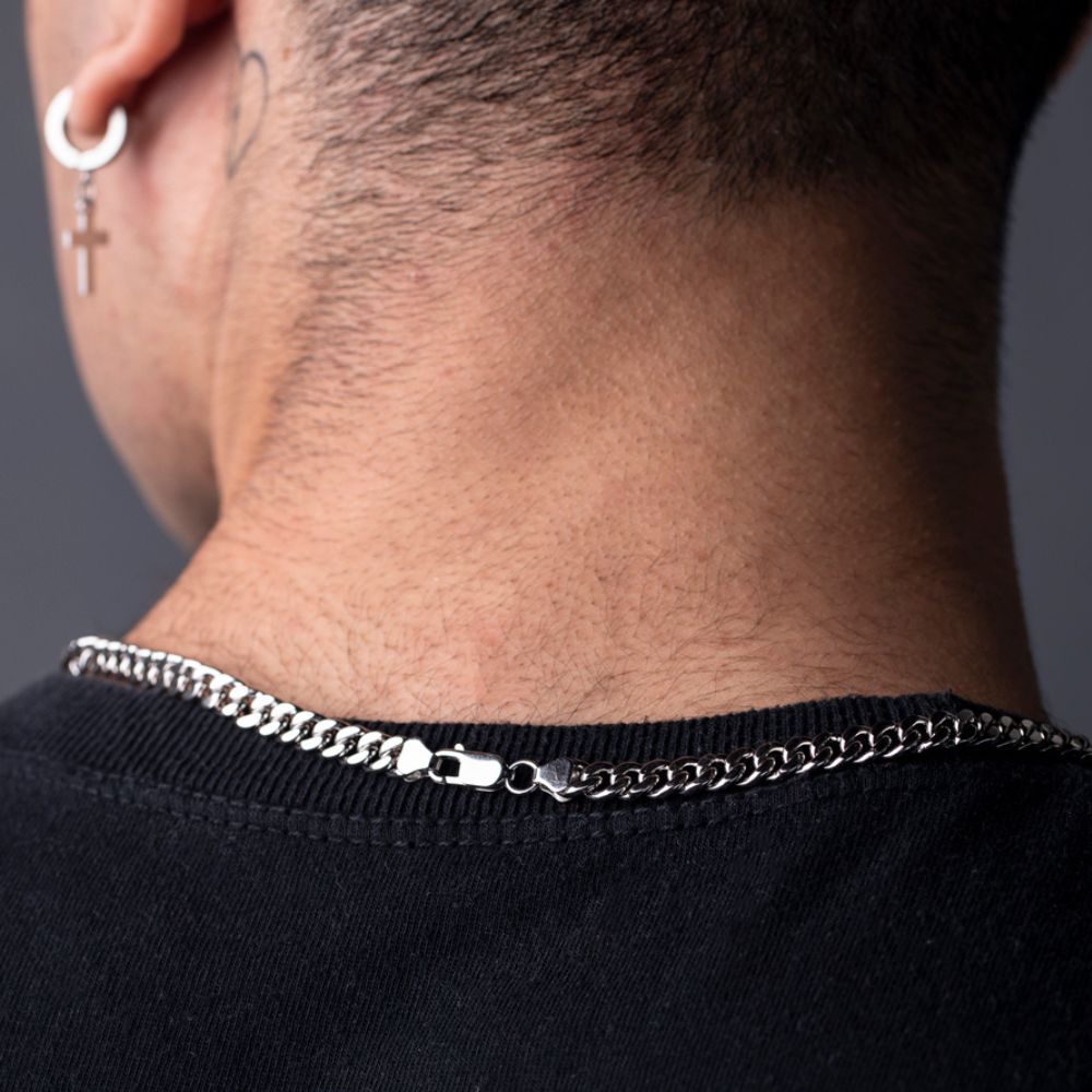 Back view of silver Cuban chain clasp on man's neck, earrings visible