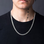 Close-up of man wearing 925 silver Cuban link necklace over black shirt