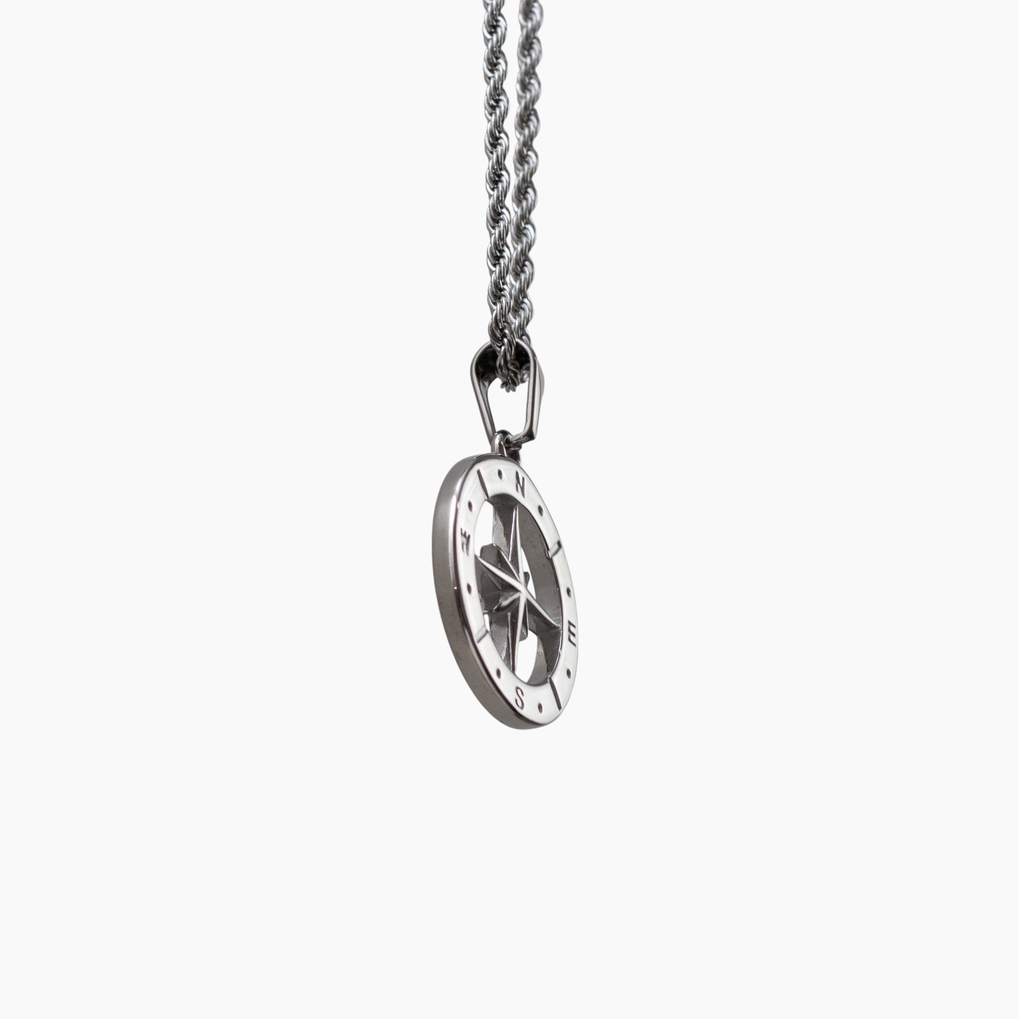 Silver compass pendant on a chain against a white background
