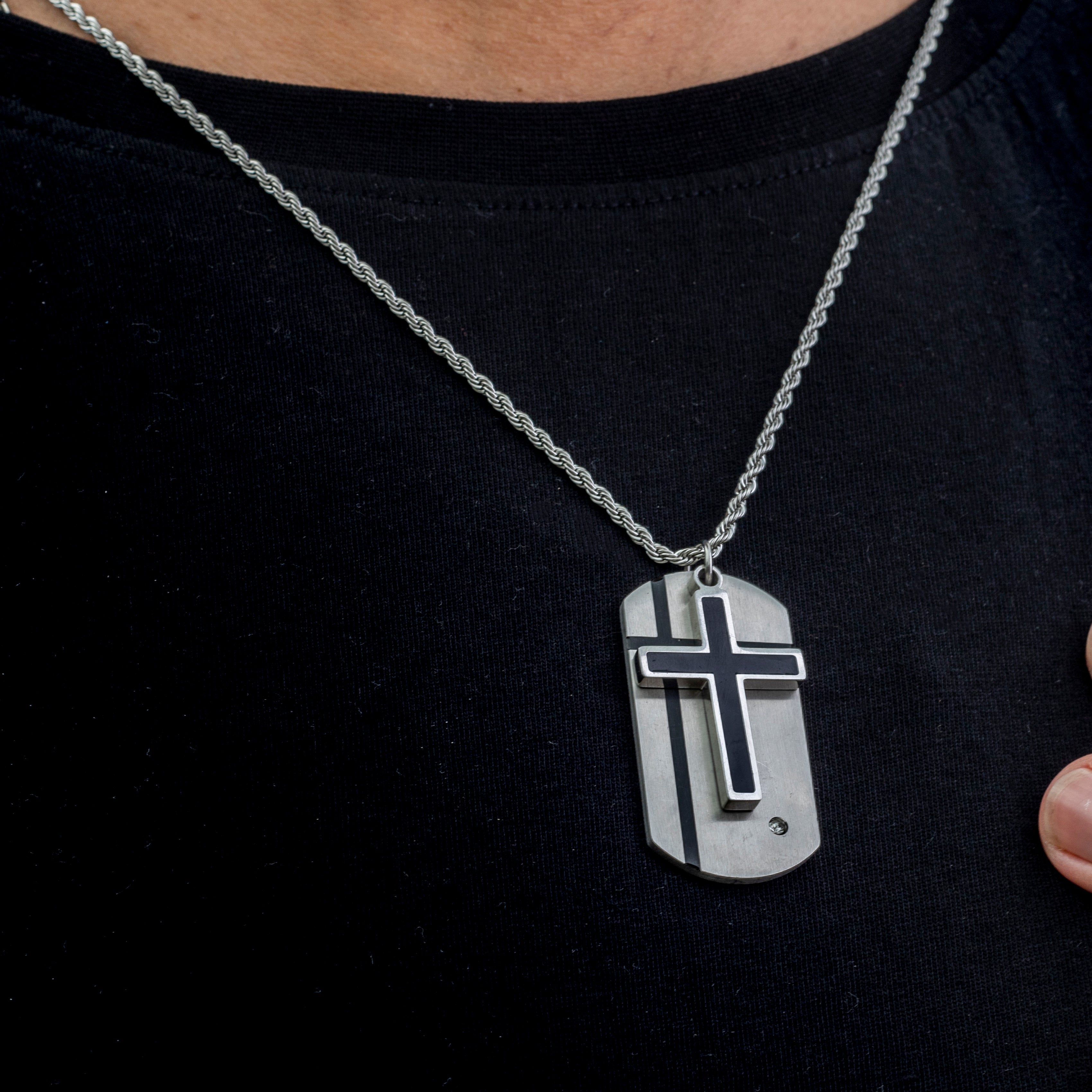 Silver necklace with a cross pendant on a black shirt