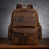 Full-grain leather backpack, front view with zip pockets and buckle straps