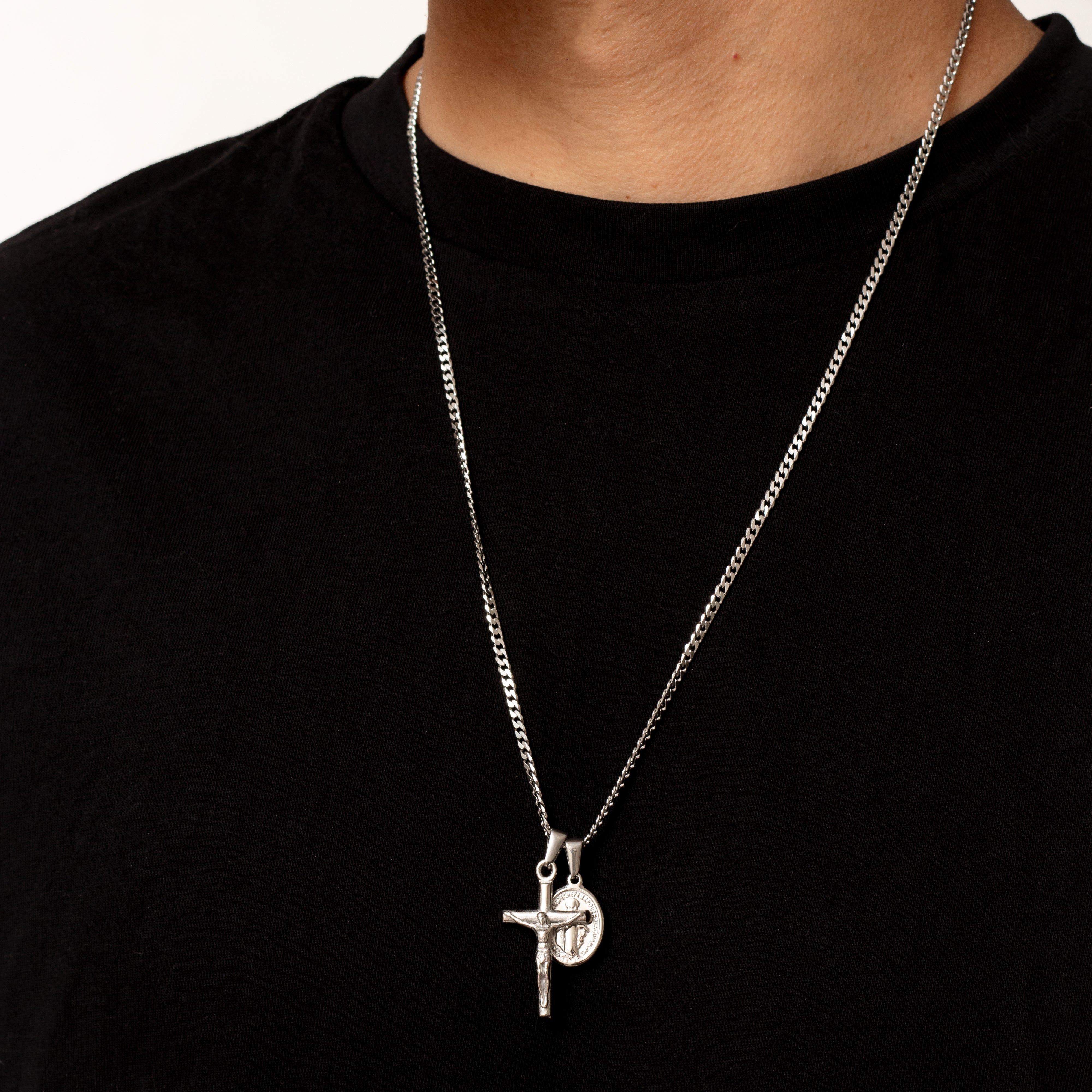 Silver necklace with a cross pendant on a black shirt